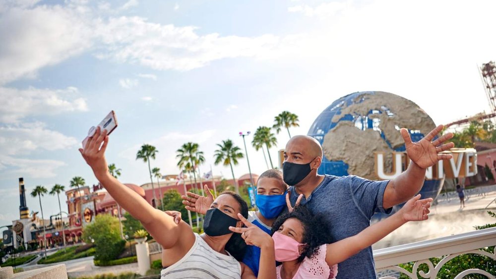 A family posing in front of the Universal globe