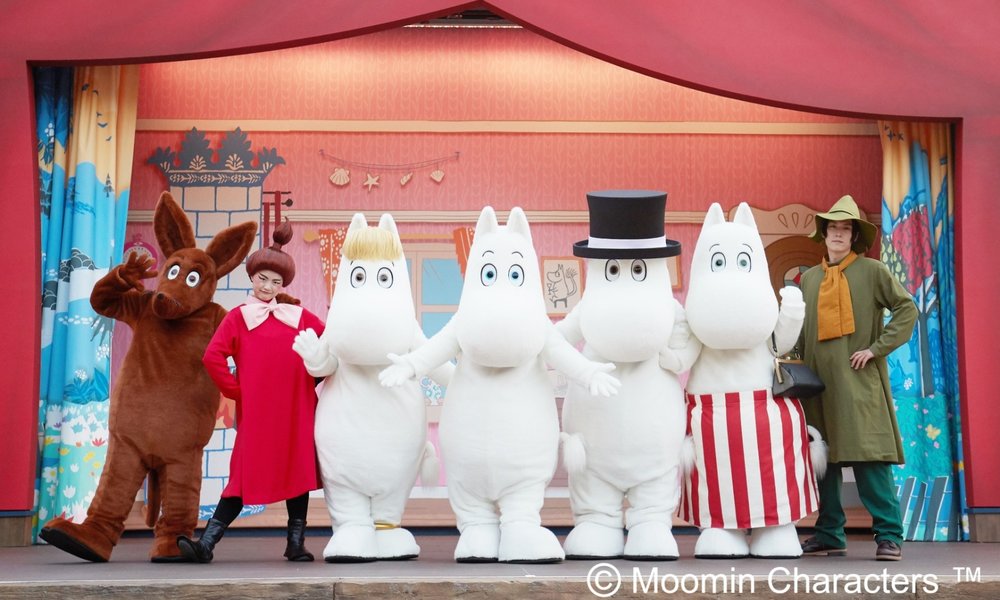 Staff smiling for a photo with Moominvalley mascots