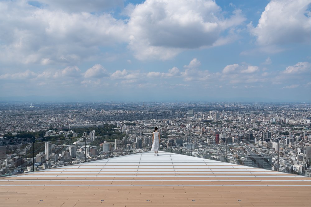 Girl in white standing at the edge of an observatory deck