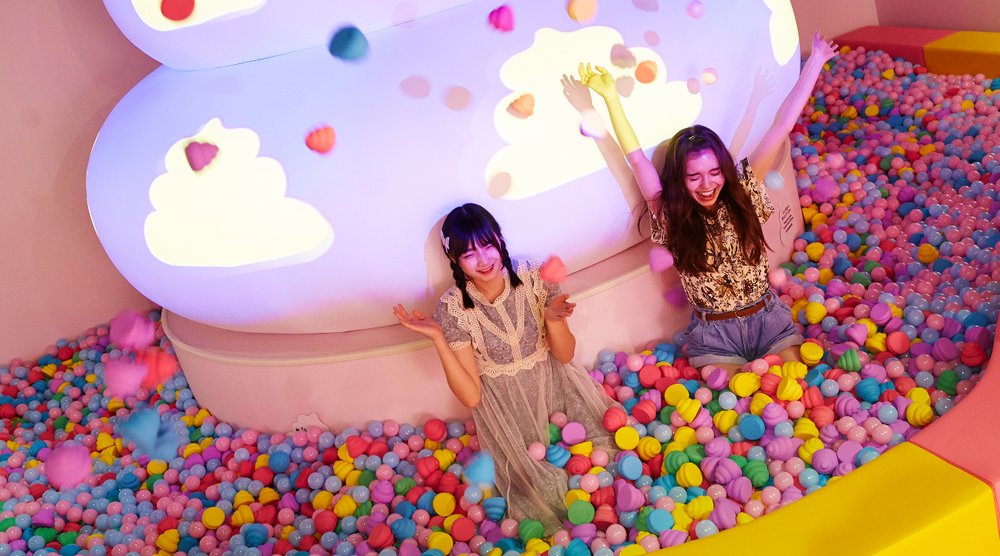 Two ladies in a rainbow-colored poop pit