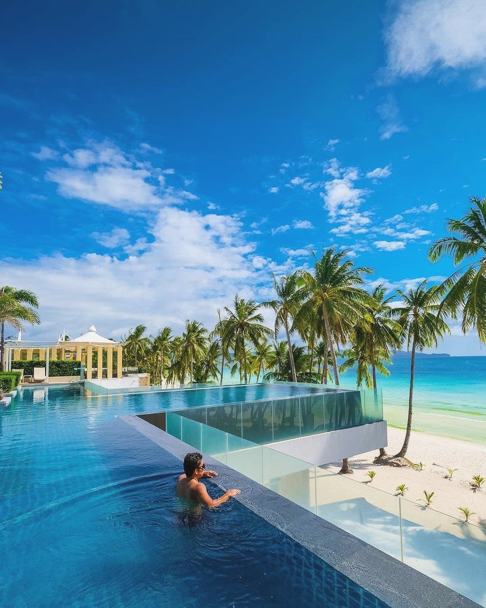 Man swimming in the pool with the view of the beach