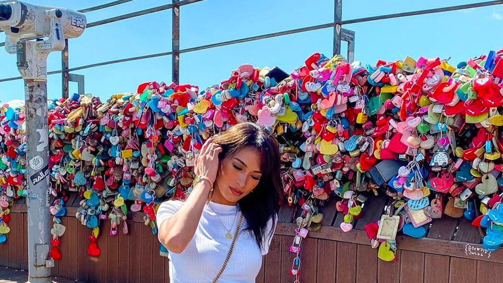 a girl posing in front of the Namsan Love Locks at N Seoul Tower
