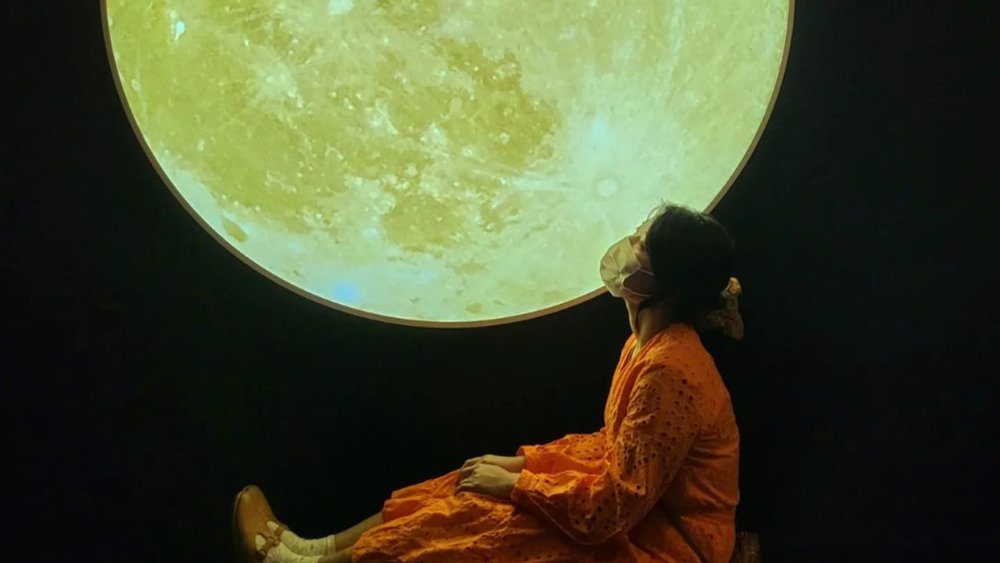 a woman by the moon in the 63 Building Observatory