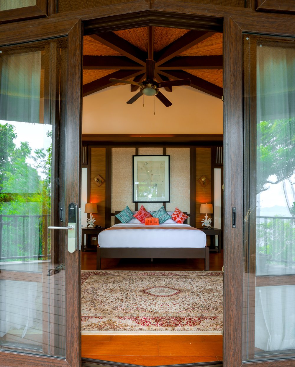 balcony door opening to tropical bedroom