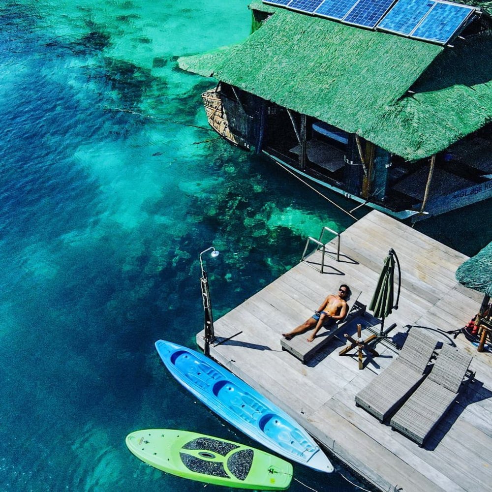 A view of man resting surrounded with clear blue water