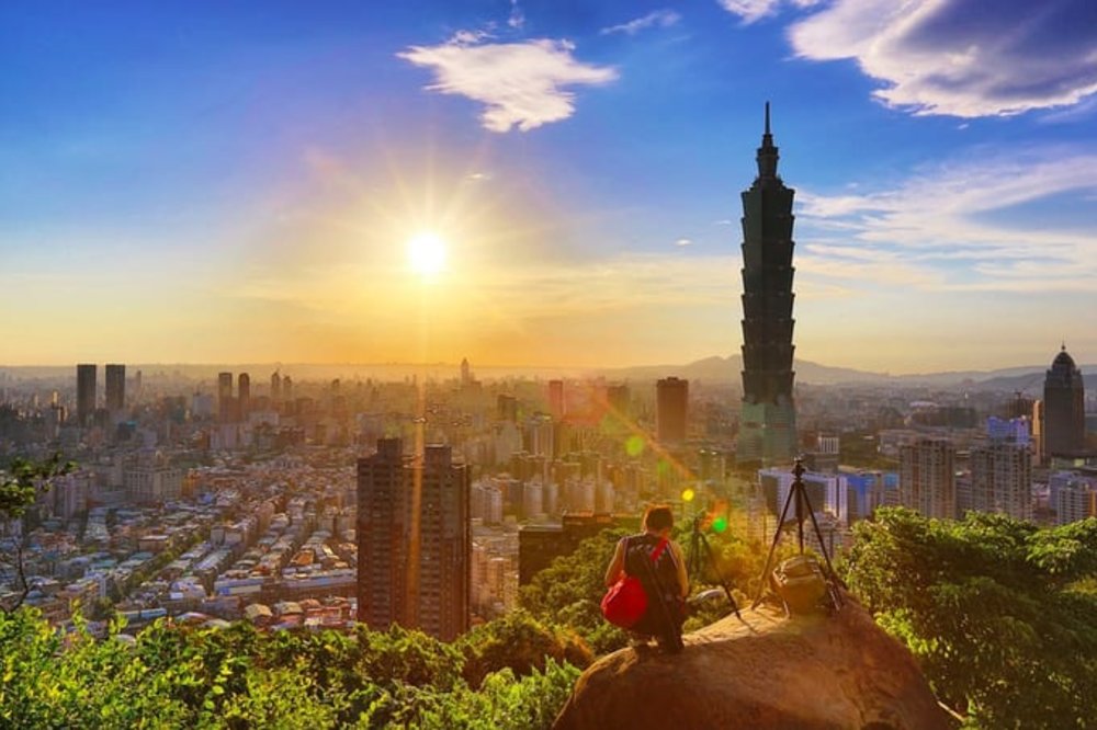 Man atop a hill looking over buildings
