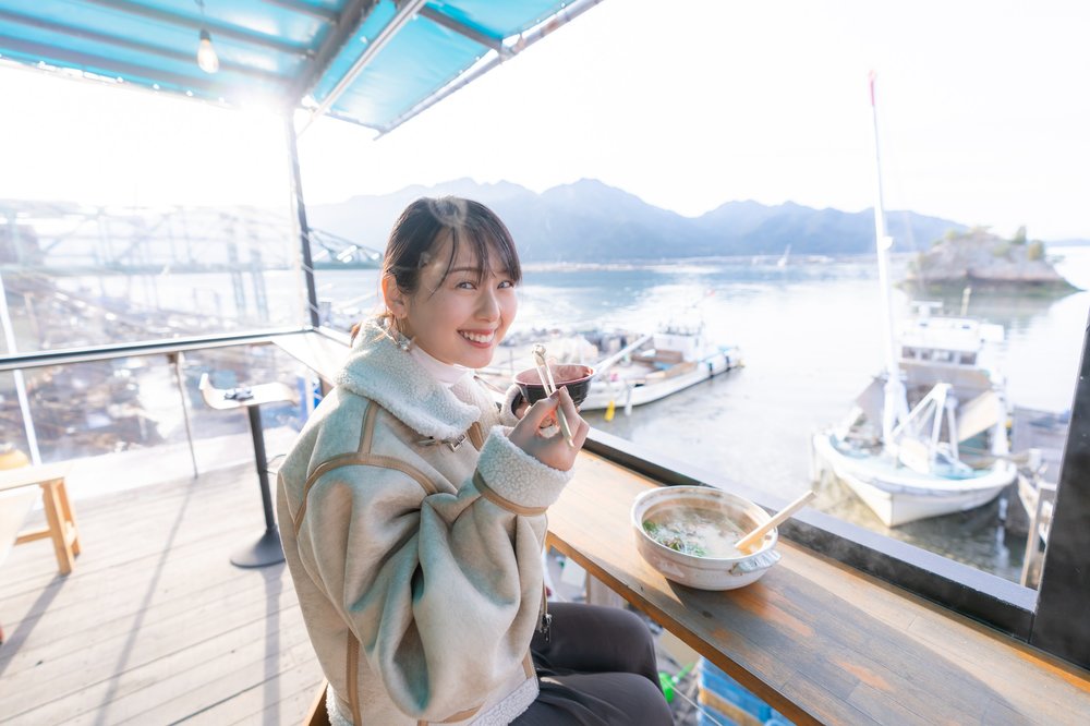 Girl having a bowl of oysters by the sea 