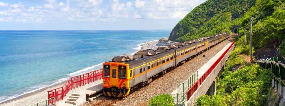 Train running beside the ocean