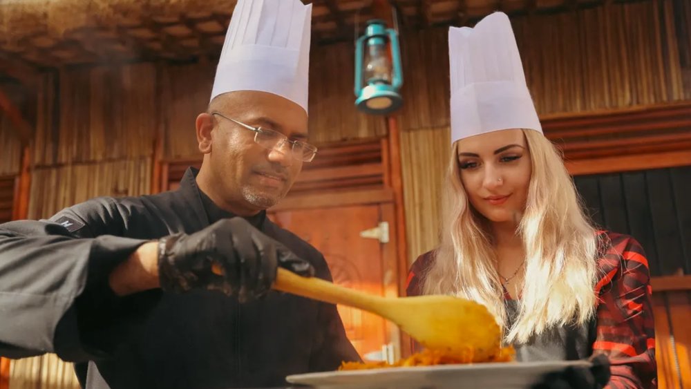 a chef at Emirati Cooking Class at Al Khayma Heritage House teaching a woman how to cook