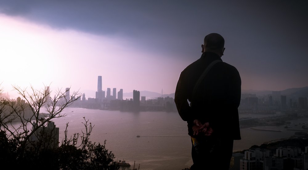 man looks over view of hong kong from devil's peak trail
