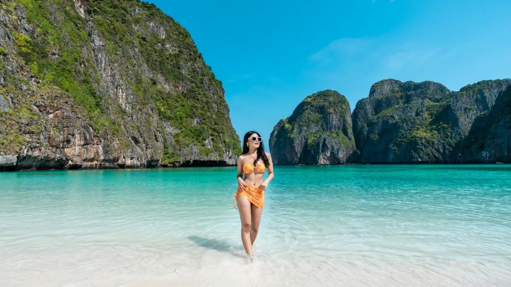 a woman wearing a bikini and posing at a beach in Thailand
