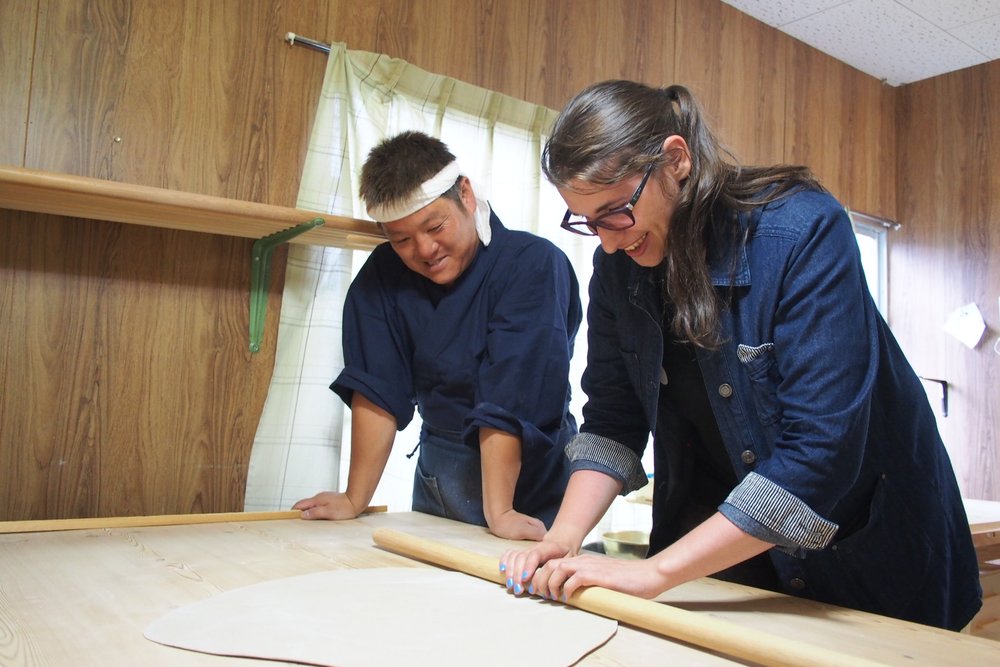 A professional and a student making noodles