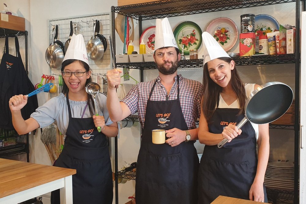Three people all suited up for a cooking workshop