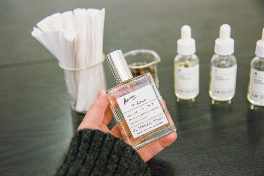 Person holding a bottle of perfume