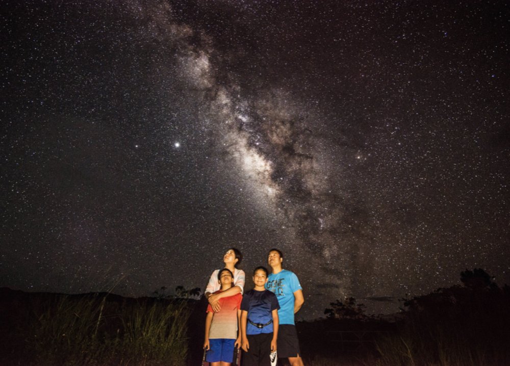 a family gazing at the bright starry sky