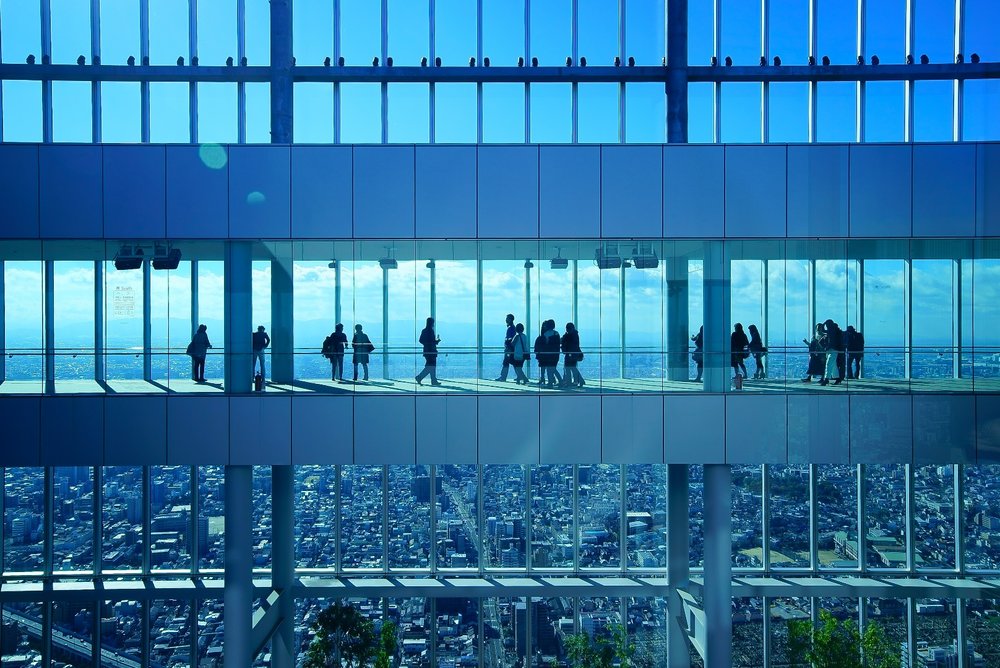 people walking inside glass building