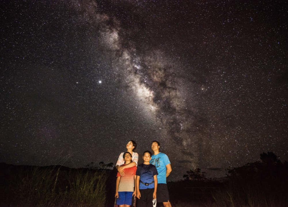 family looking up at starry sky