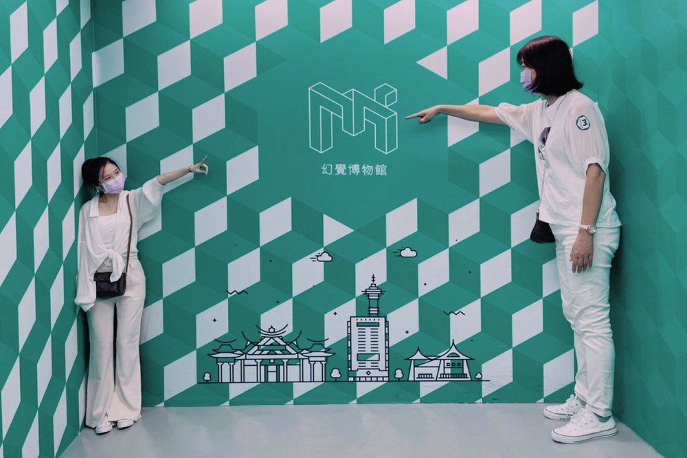 Two people posing for a photo with one of the art pieces in a museum