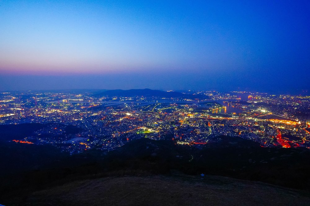 a scenic city view from the top of a mountain
