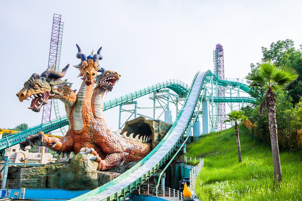 a large rollercoaster ride with a three-headed dragon statue