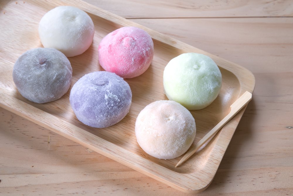 Different-colored mochi balls on a wooden plate
