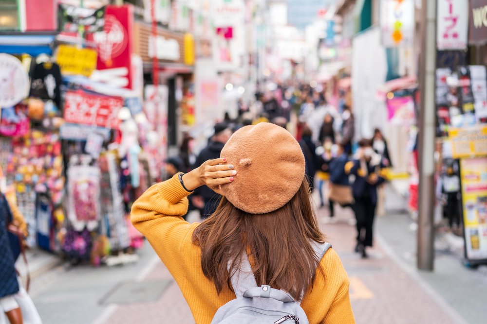 girl with beret in front of busy street