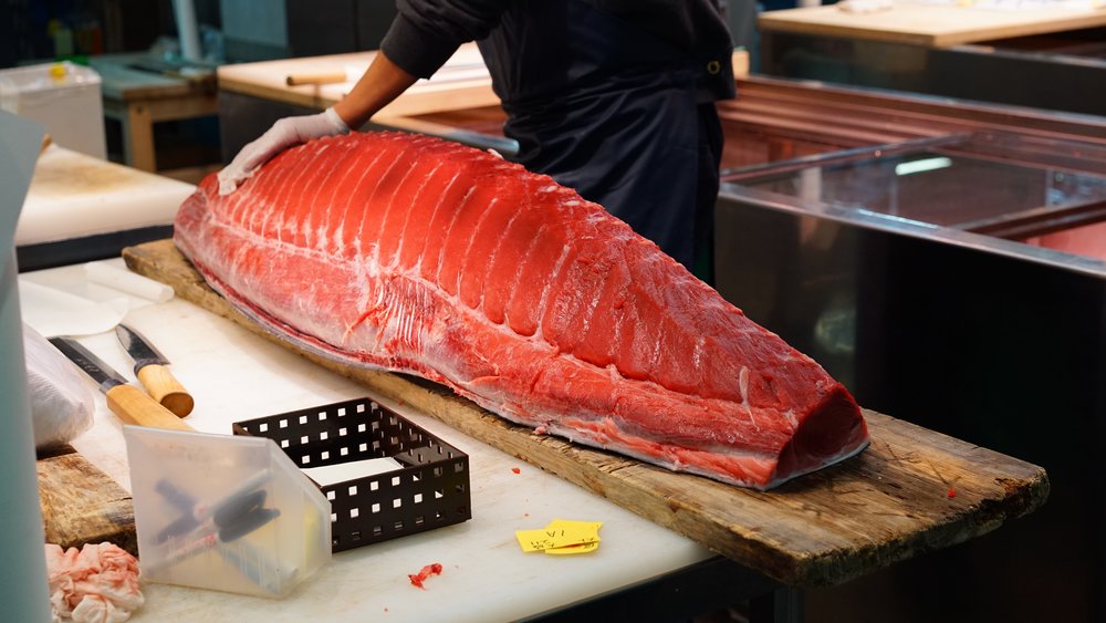 man slicing raw tuna