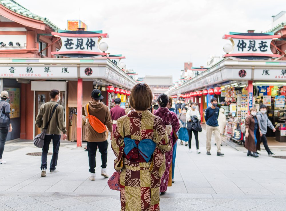 lady in kimono facing a busy walkway