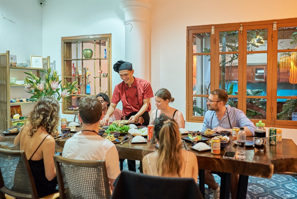 people gathered around a dining table and about to eat a nicely prepared meal