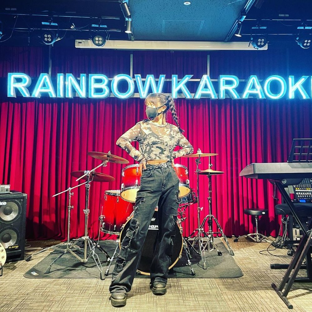 Girl standing in front of drum set