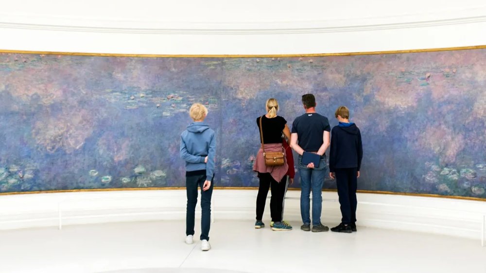 people viewing Monet's Water Lilies inside Musée national de l’Orangerie