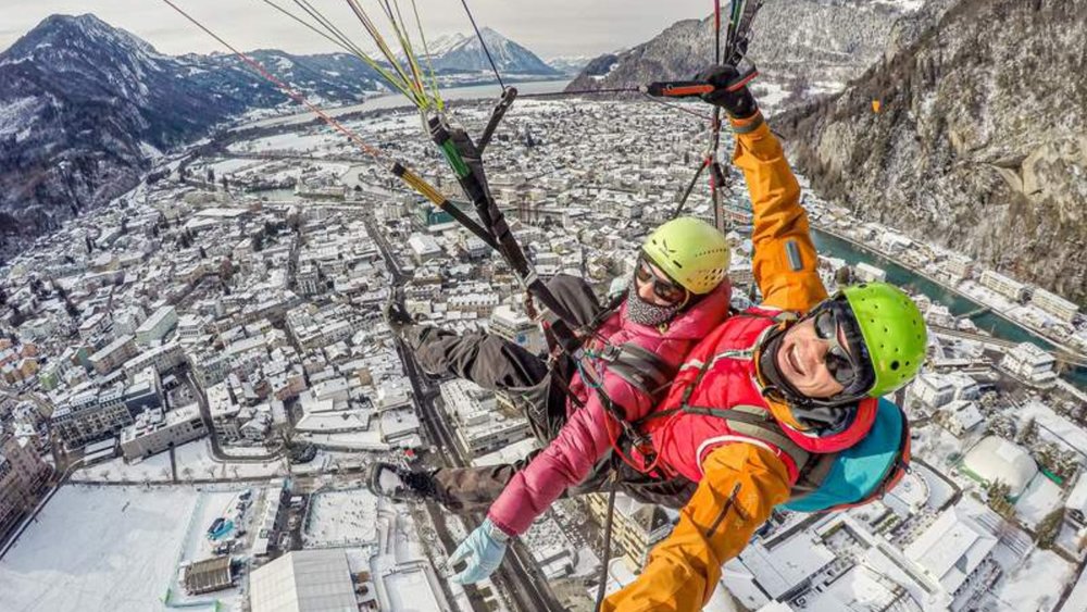 people taking a selfie while paragliding in Interlaken during the winter