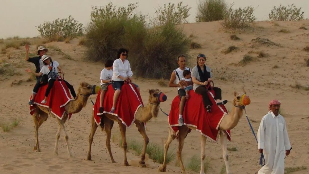 people riding on camels in Dubai