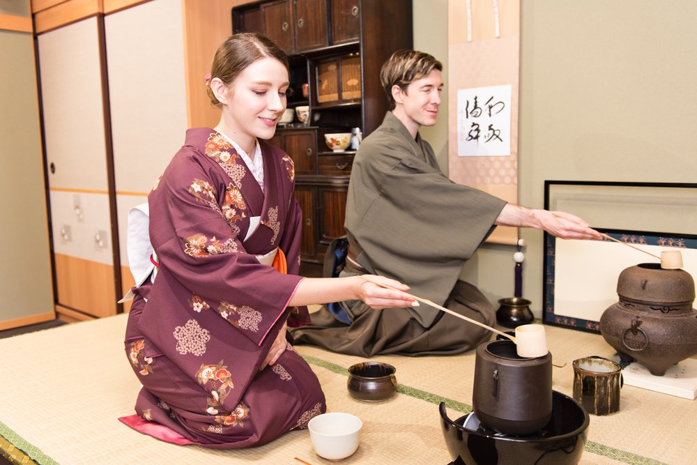 Man and woman in kimonos making matcha tea