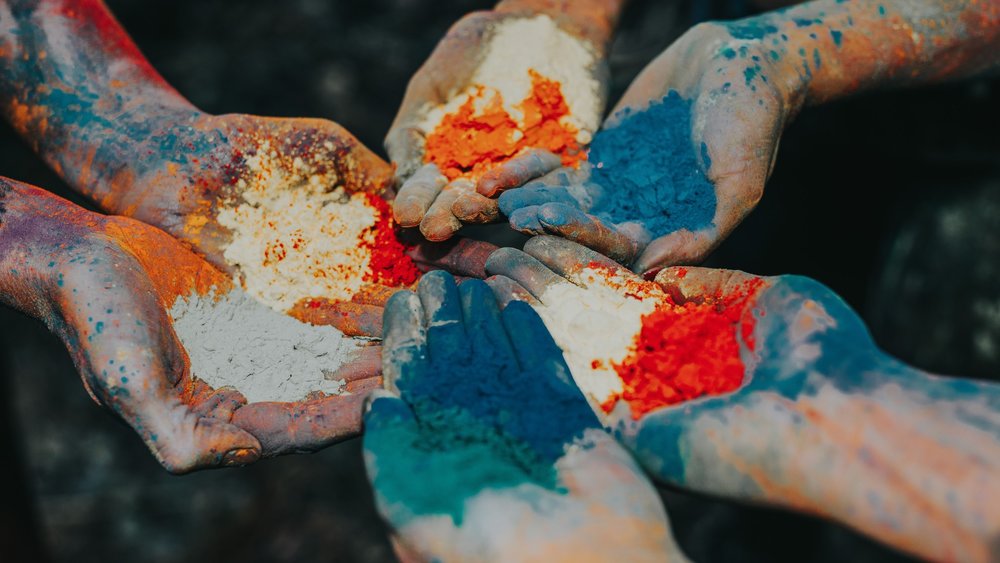 hands holding out colored powder at The Holi Festival