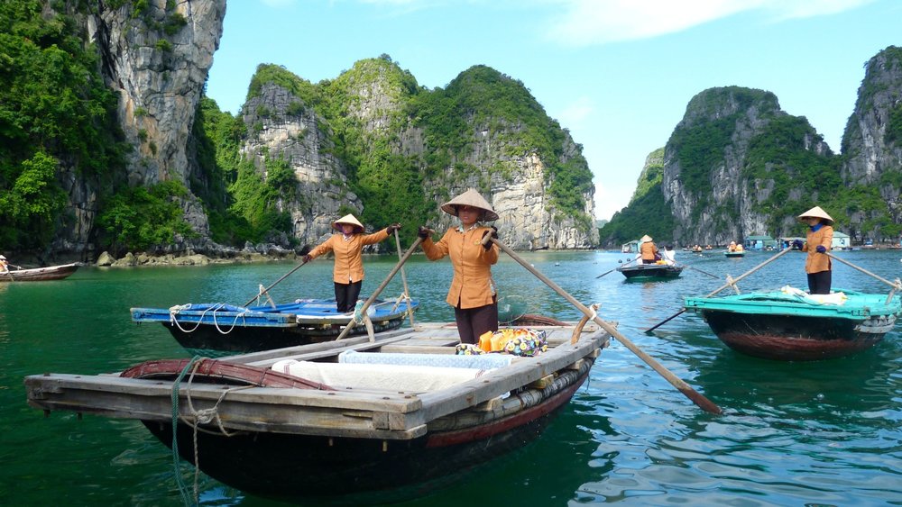 people riding boats in Halong Bay