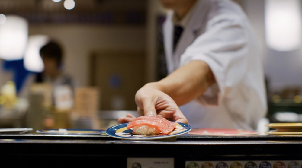 Man serving a plate of sushi