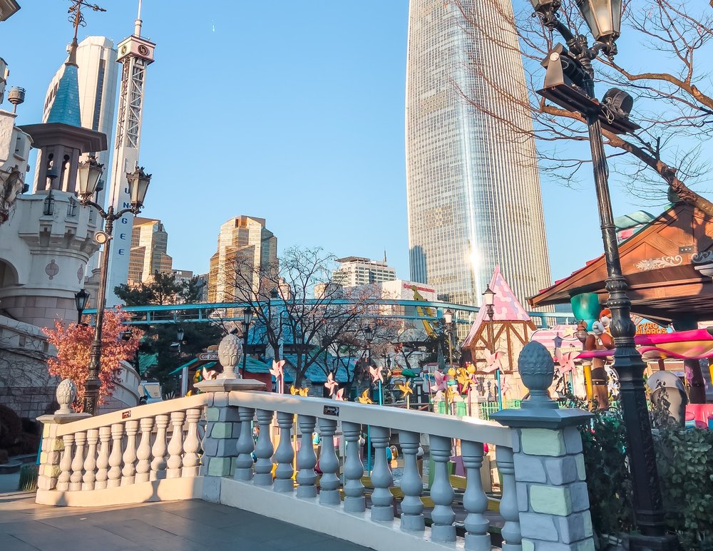 bridge overlooking tall building and amusement park