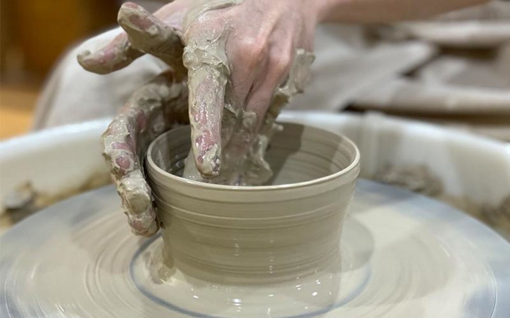 Person turning clay into a pot