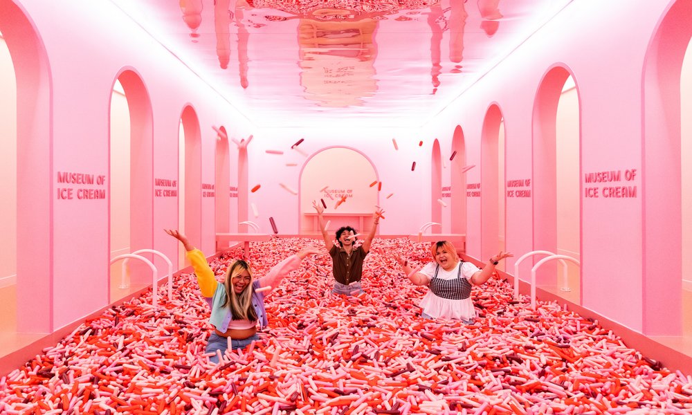 Three people in a pool of sprinkles