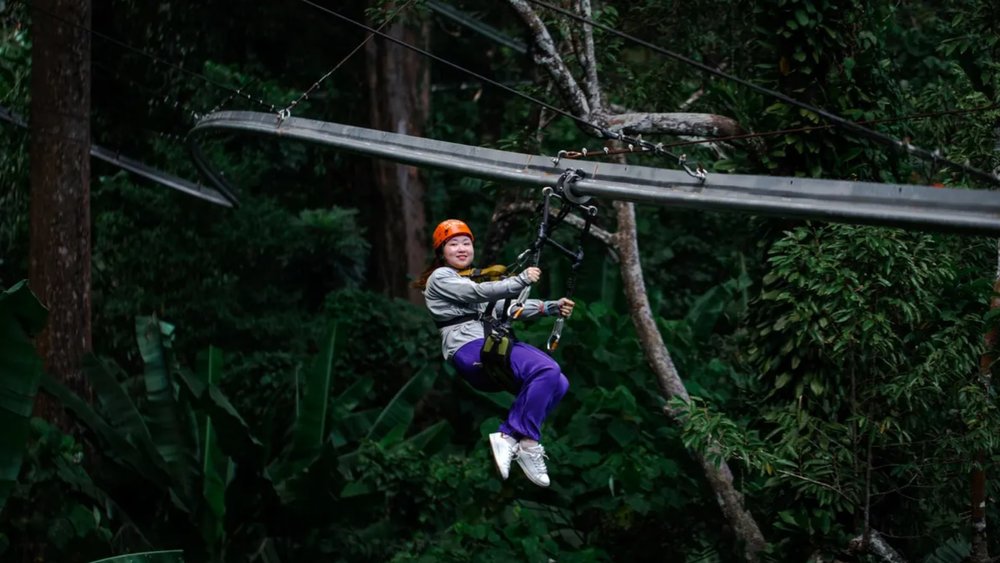 woman ziplining through the jungle