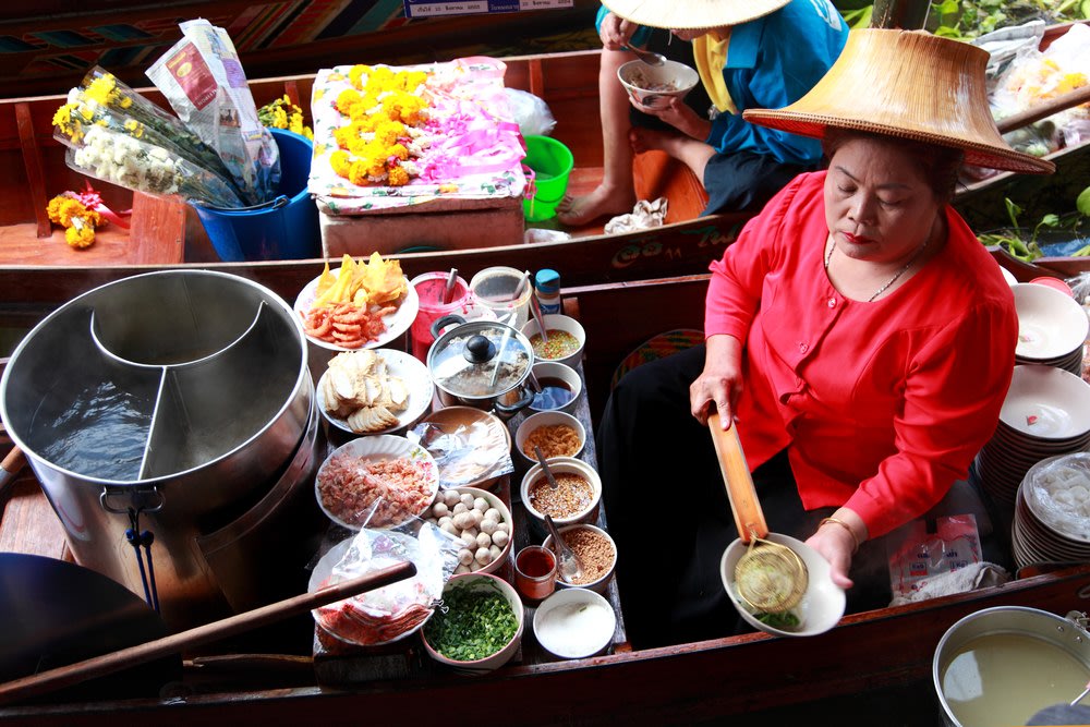 Vendor selling in the river market in thailand