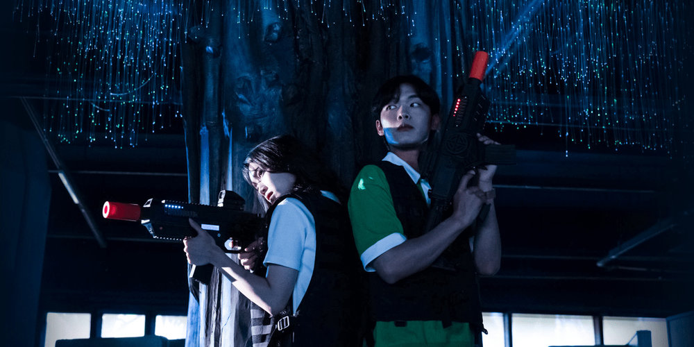 two friends holding toy guns at an amusement park