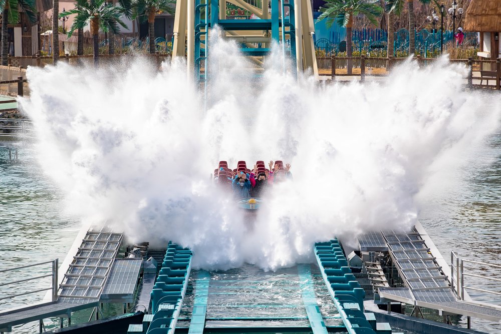rollercoaster splashing those in the ride as it descends in water