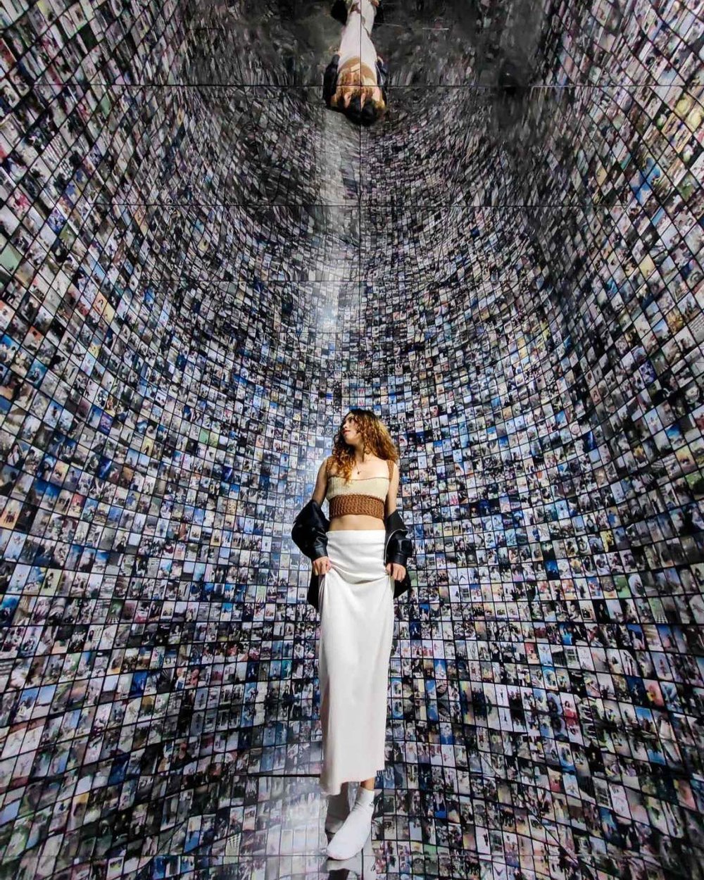 Girl posing in a wall full of pictures