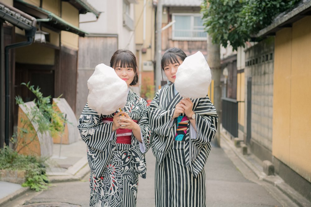 Two girls in kimono eating cotton candy