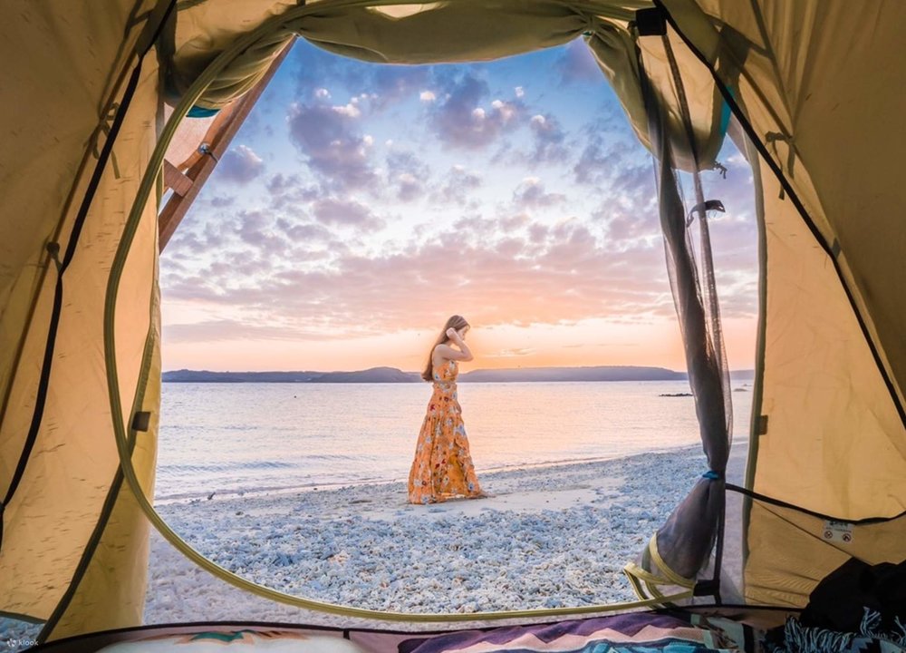 woman walking on beach outside tent
