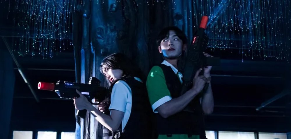 Man and woman holding guns for laser tag