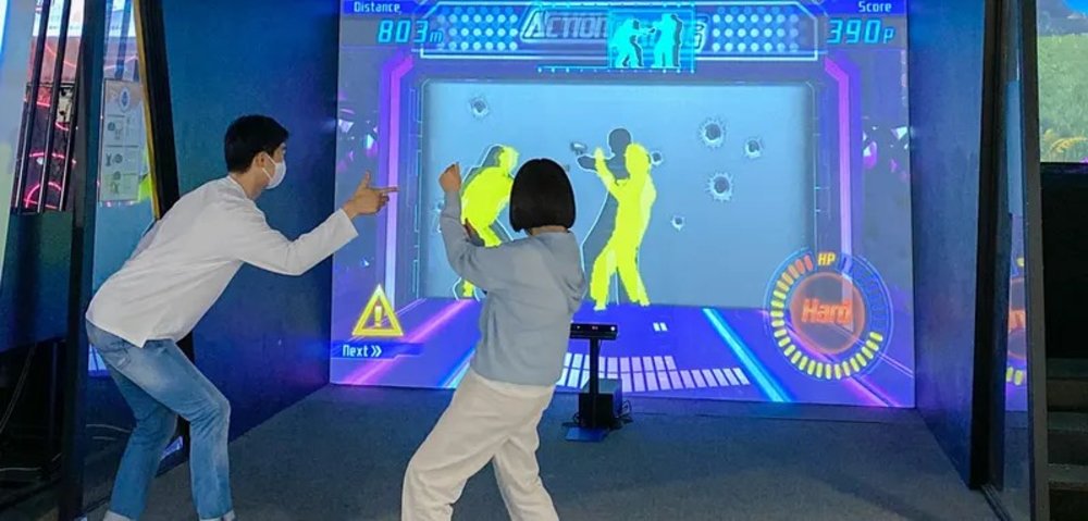 Man and woman playing sports on a large screen