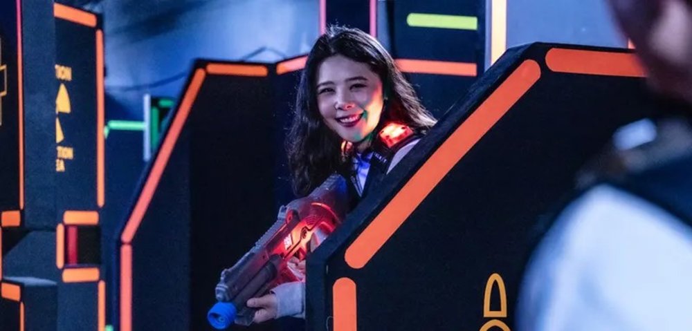 Woman smiling while holding a gun for laser tag